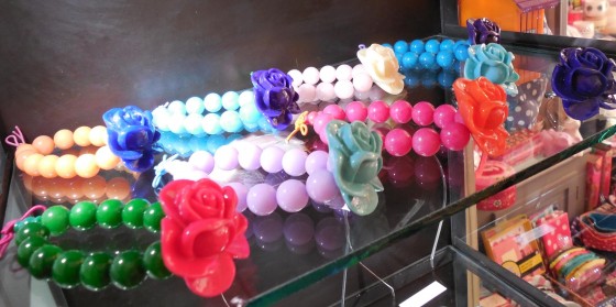 Bracelets en perles de verre et roses en acrylique (14 euros), bagues assorties (8 euros)